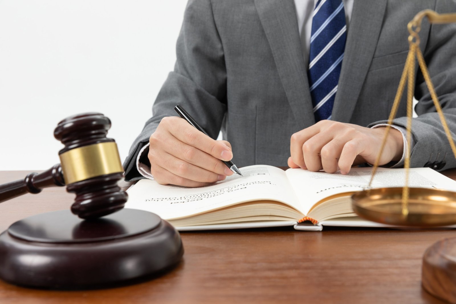 closeup shot person writing book with gavel table